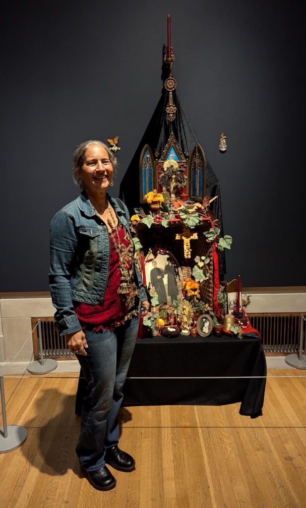 An intricate ofrenda combining family memorabilia, Greek iconostases, and Day of the Dead elements. Adorned with marigolds, candles, and photographs, it features 'Ottillie’s Basket' alongside tokens like prayer beads, grapes, and bread, celebrating remembrance and ancestral connections.