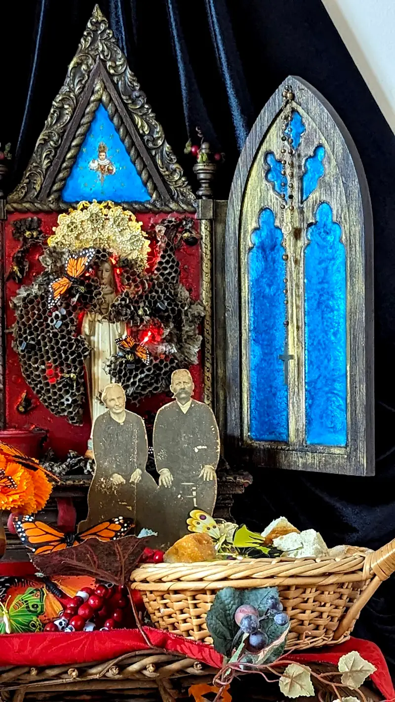 An intricately designed family altar featuring memorabilia from Ottillie’s Basket, a Greek iconostasis, and traditional ofrenda elements like marigolds, candles, and photographs, symbolizing the connection between past and present.